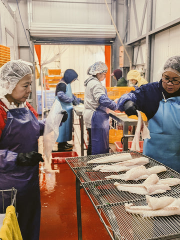 Women cutting and prepping raw fish