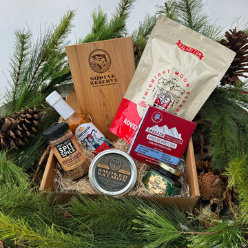 Gift box with Kodiak Reserve products surrounded by pine branches and pinecones.